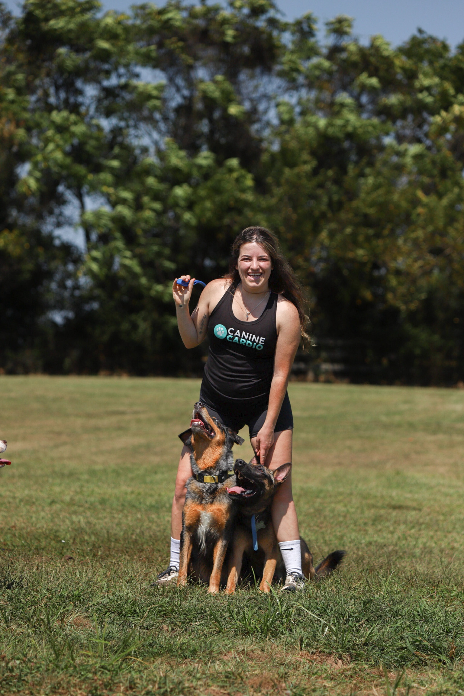 Brittany Schneller, Founder and Head Trainer of Canine Cardio, with two German Shepherds