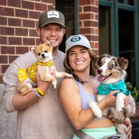 Brittany Schneller and Daniel Ramos, co-owners of Canine Cardio, holding their dogs